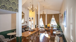 A spacious room with a wooden bar, seating areas, and a large window with curtains. - Washington Square Inn (San Francisco)