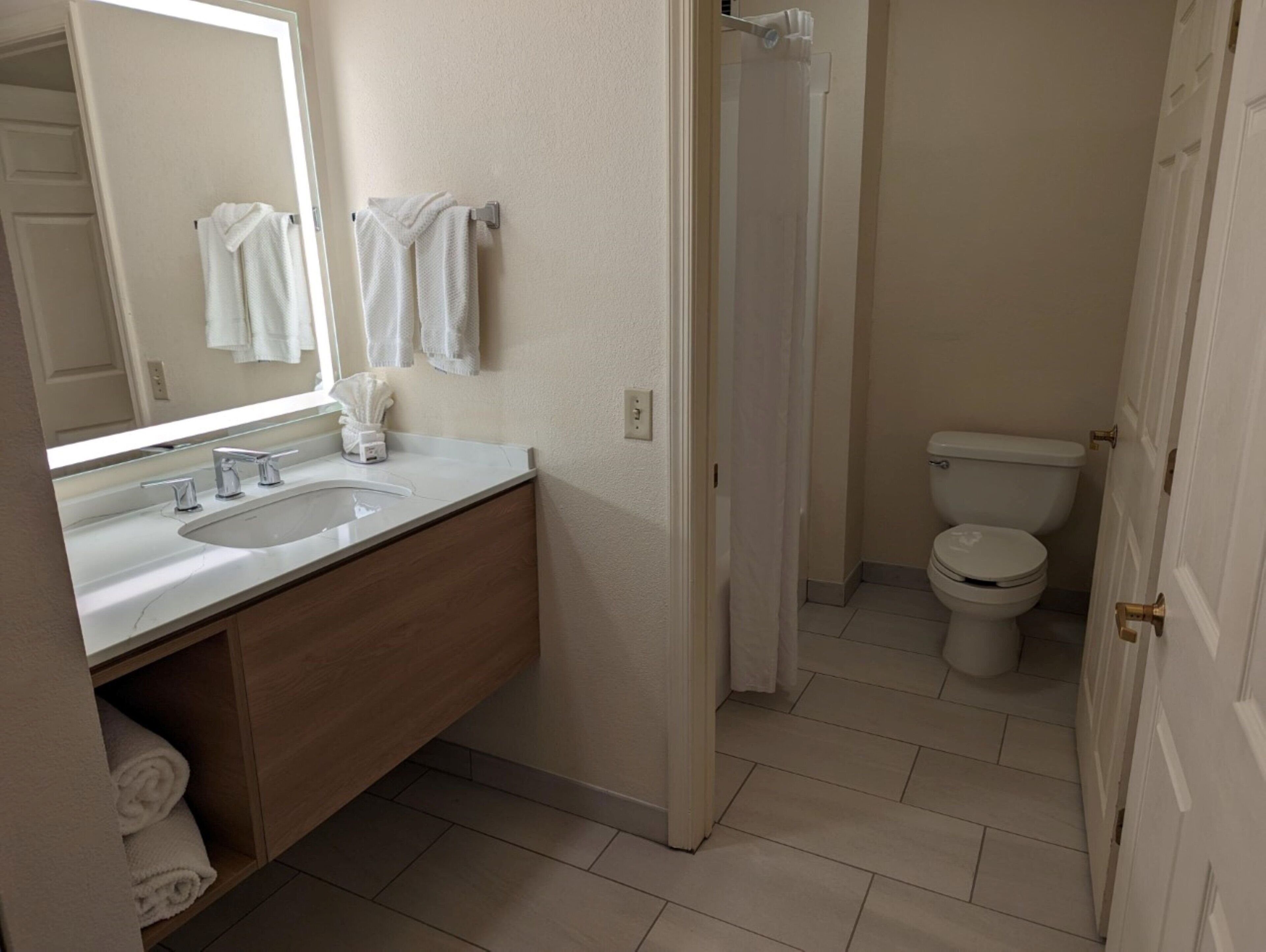 Ein Badezimmer mit Waschbecken, Spiegel und Toilette.