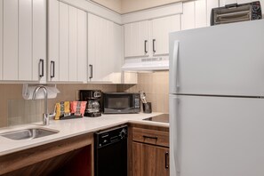 A kitchen with white cabinets, a stainless steel sink, a microwave, a coffee maker, and a dishwasher. - Staybridge Suites Allentown Bethlehem Airport by IHG (Allentown)