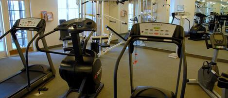 A gym with treadmills, elliptical machines, and weight equipment.
