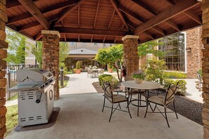 An outdoor patio with a grill, stone pillars, and a covered seating area with chairs and tables. - Staybridge Suites Allentown Bethlehem Airport by IHG (Allentown)