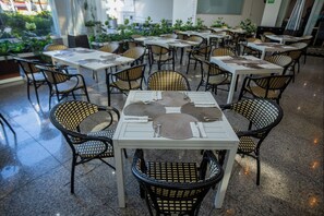 A restaurant with multiple tables and wicker chairs, arranged in a spacious outdoor setting with potted plants. - Crowne Plaza Mexico City North-Tlalnepantla by IHG (Tlalnepantla de Baz)