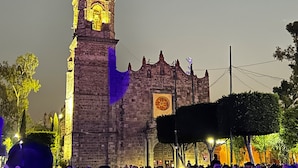 A historic building with a prominent clock tower, surrounded by a crowd of people.