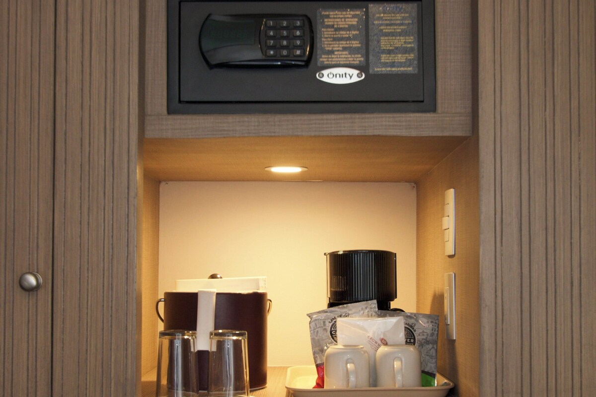 A compact kitchenette with a built-in microwave, a coffee maker, and a small refrigerator.