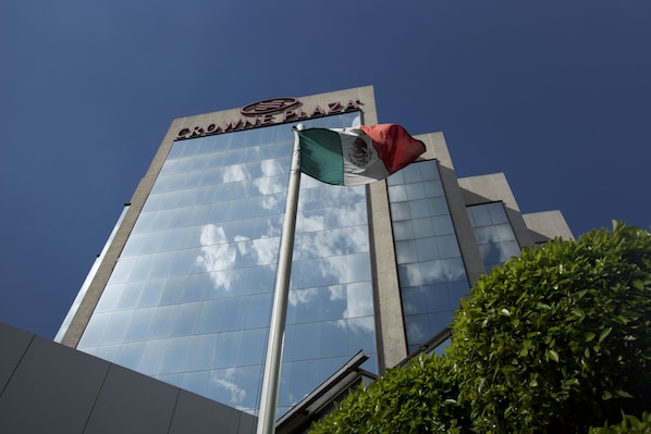 A building with a glass facade and a flagpole with a flag.