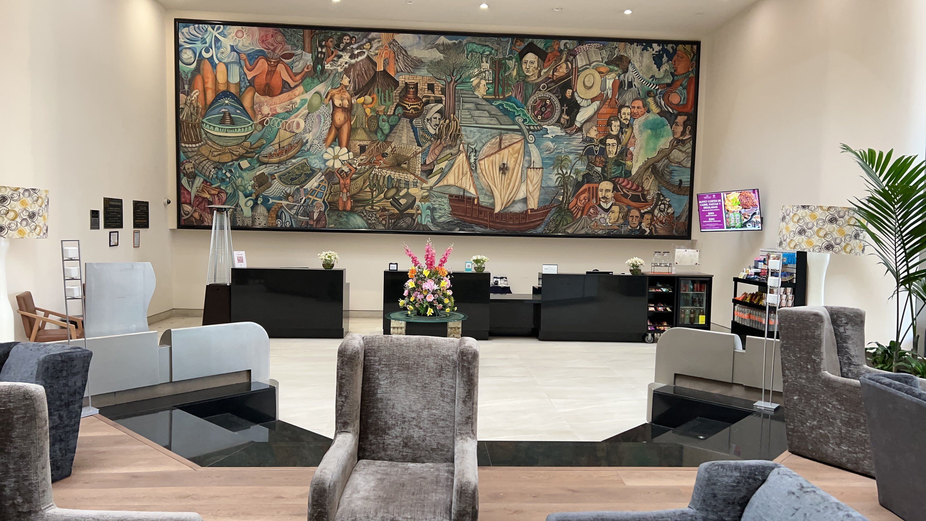 A reception area with a large mural, modern furniture, and a reception desk.
