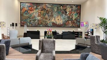 A reception area with a large mural, modern furniture, and a reception desk.