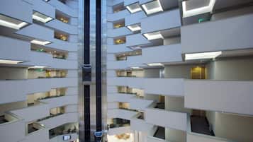 A multi-level hotel interior with a central atrium, balconies, and a visible elevator shaft.