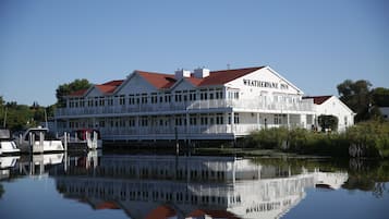 Situated by a calm body of water, the Weatherine Inn offers a serene environment surrounded by lush greenery and trees.