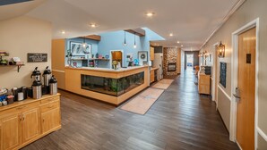 A modern kitchen with a central island, wooden cabinets, and a coffee station. - The Weathervane Inn (Montague)