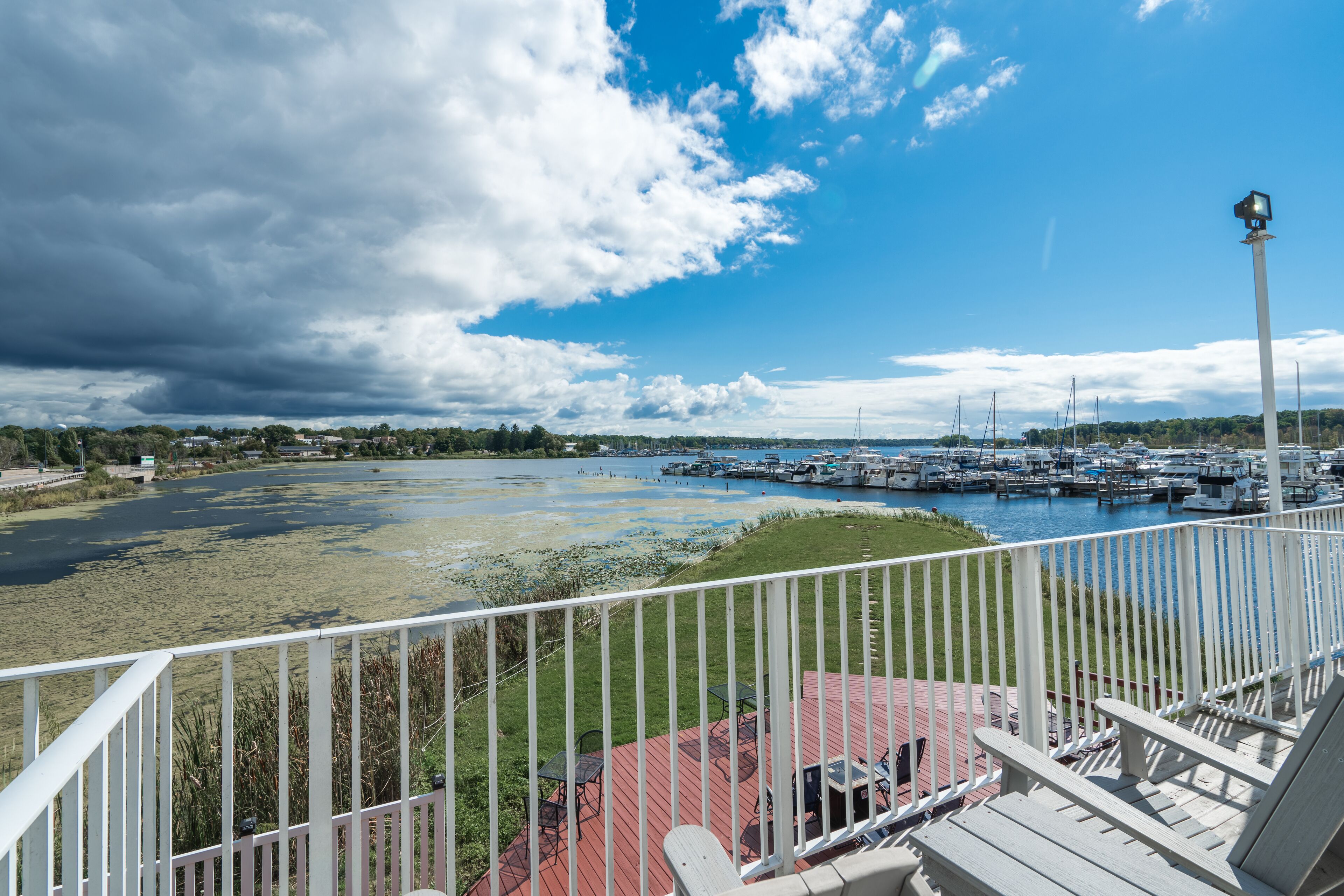 A marina with boats docked, a clear sky, and a view of the water.