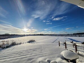 A snow-covered landscape with a clear sky and a distant view of a structure.