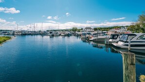 A marina with boats docked, calm water, and buildings in the background. - The Weathervane Inn (Montague)