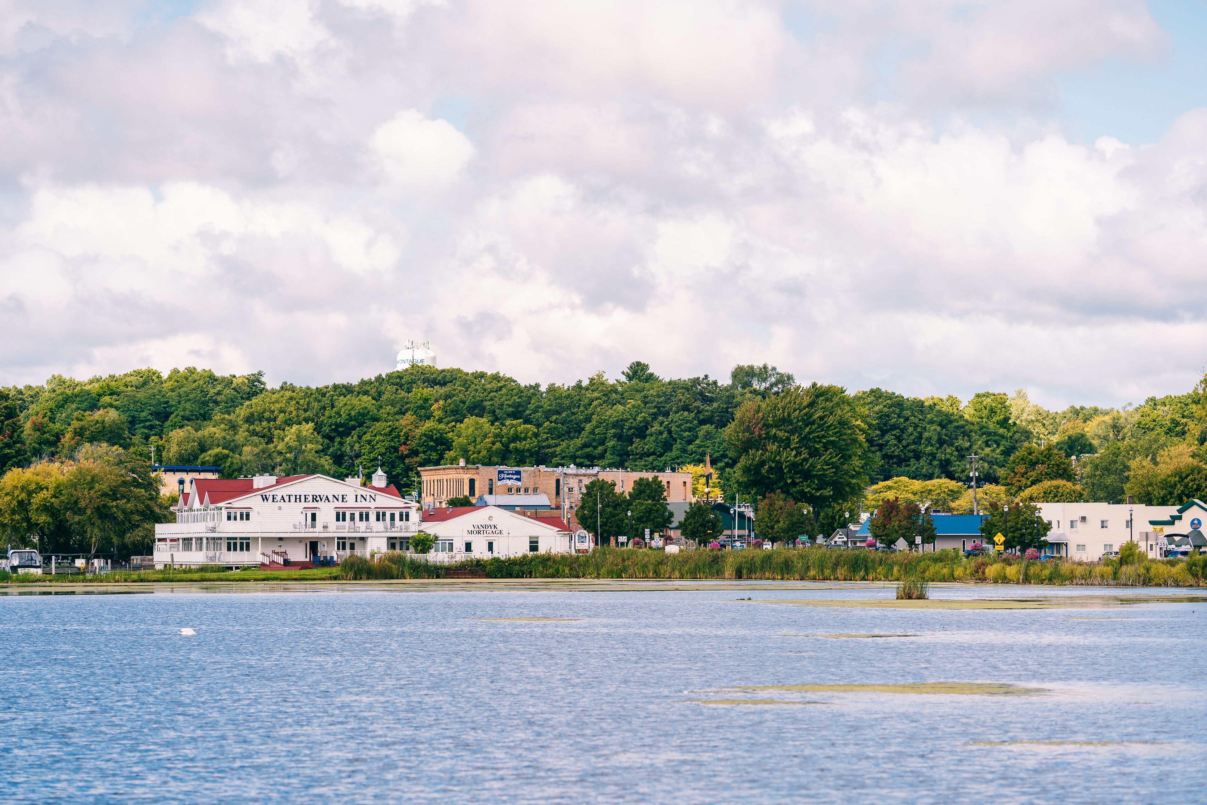 A waterfront hotel with a red roof, a visible restaurant, and a view of the lake.