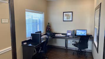 Un centre d’affaires équipé de deux bureaux, d’ordinateurs et d’un petit sapin de Noël.