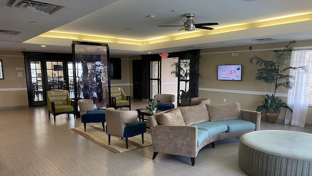 A spacious lobby with a beige sofa, armchairs, and a coffee table.