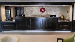 A reception area with a stone wall, a red wreath, and a HP logo on the counter.