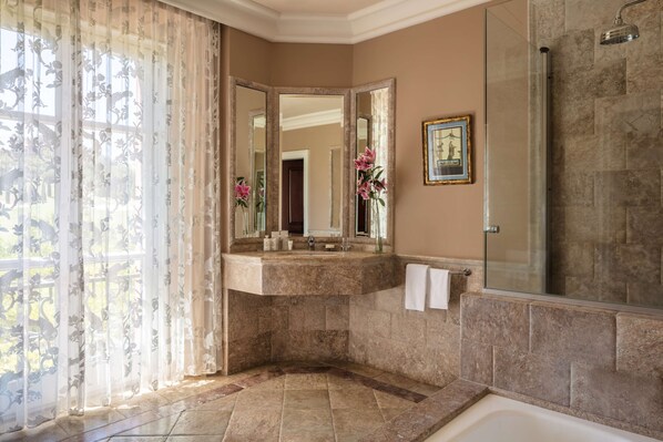 A bathroom with a large mirror, a sink, a shower, and a bathtub.