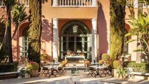 A courtyard with a fountain, outdoor seating, and a building with columns and arched windows. - Anantara Villa Padierna Palace Benahavís Marbella Resort - A Leading hotel of the world (Benahavis)