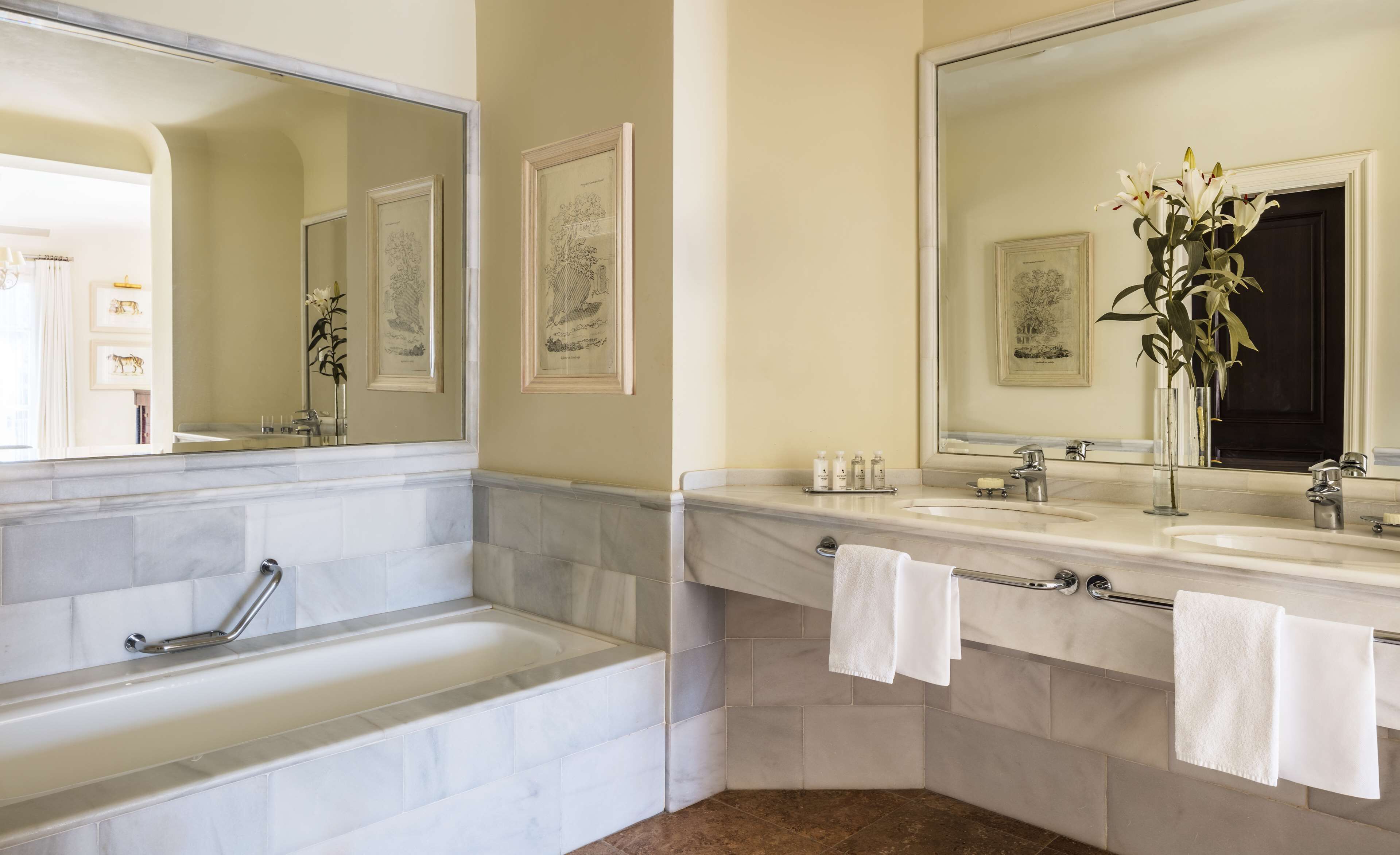 Un baño moderno con una bañera, dos lavamanos y un espejo grande.