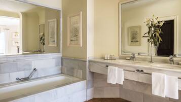 Un baño moderno con una bañera, dos lavamanos y un espejo grande.