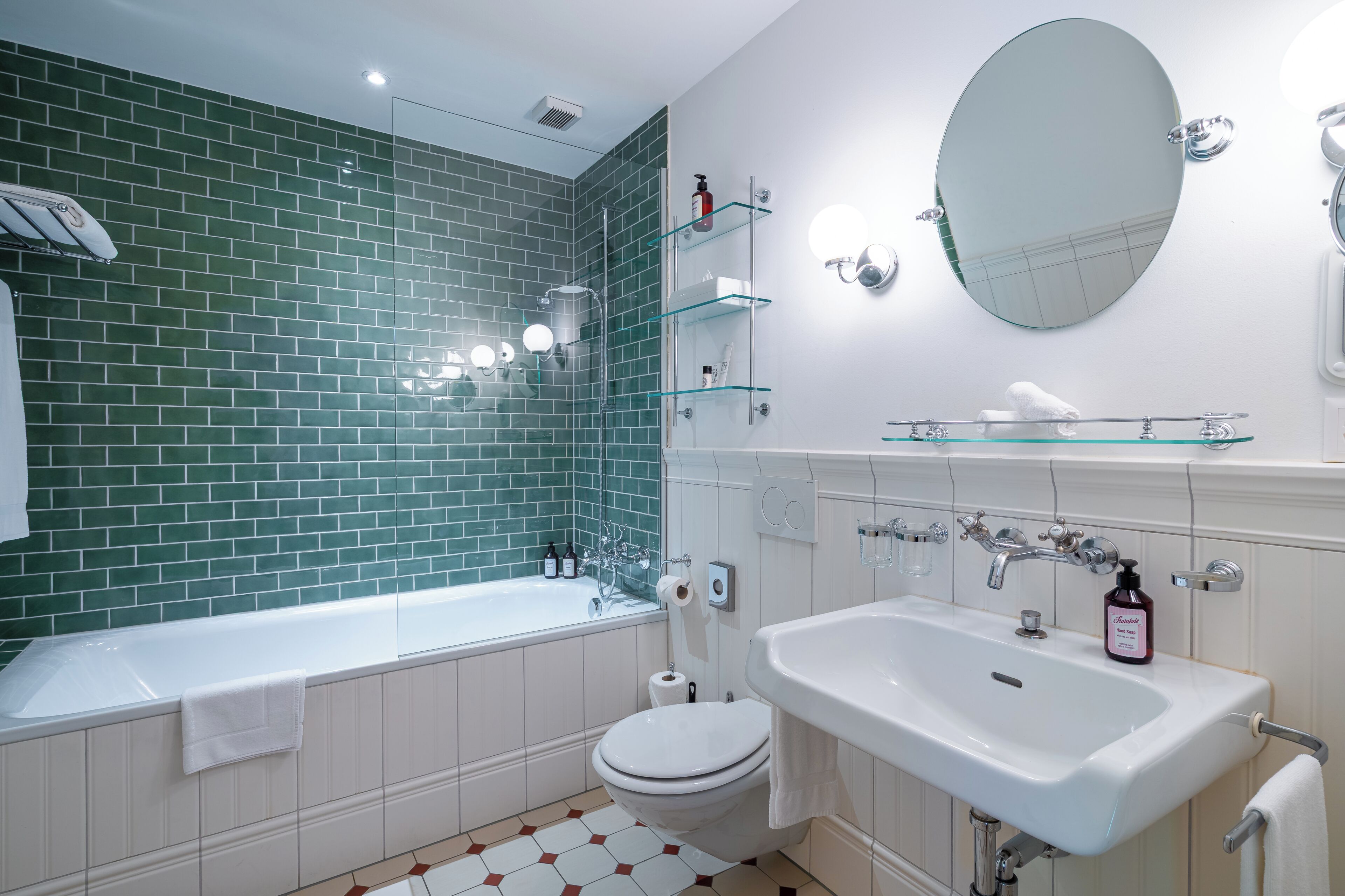 A modern bathroom with a bathtub, toilet, and sink.