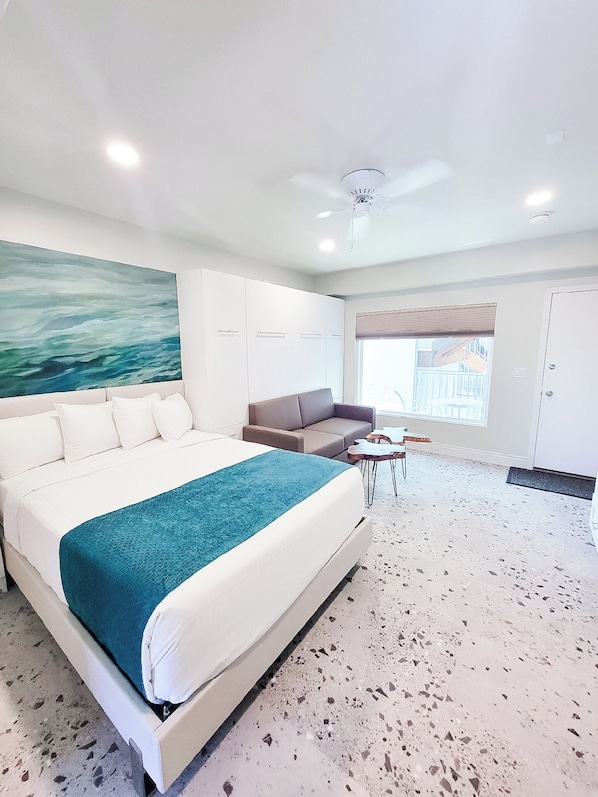 Relax in a spacious room with a large bed, sofa, and coffee table, featuring a door to a separate area.