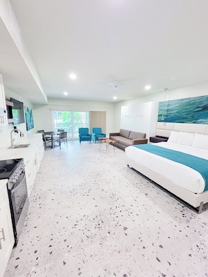 Relax in this spacious living area with a sofa, dining table, and kitchenette.
