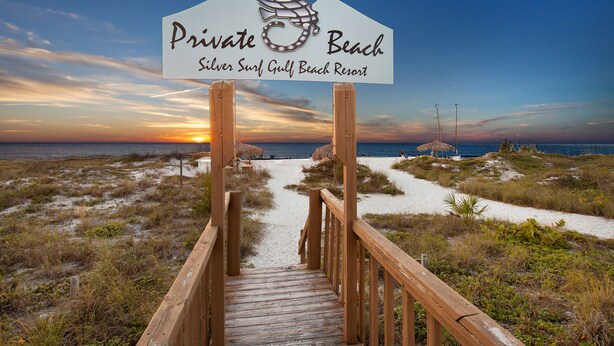 A wooden boardwalk leading to a sign for Private Beach at Silver Surf Gulf Beach Resort. - Silver Surf Gulf Beach Resort (Bradenton Beach)