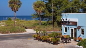 A coastal building with outdoor seating and a view of the ocean. - Silver Surf Gulf Beach Resort (Bradenton Beach)