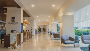 A hotel lobby with a reception desk, seating area, and large windows. - Camino Real Veracruz (Boca del Río)