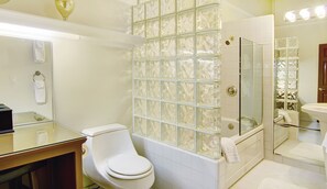 A bathroom with a glass shower enclosure, a toilet, and a sink. - Babbling Brook Inn (Santa Cruz)