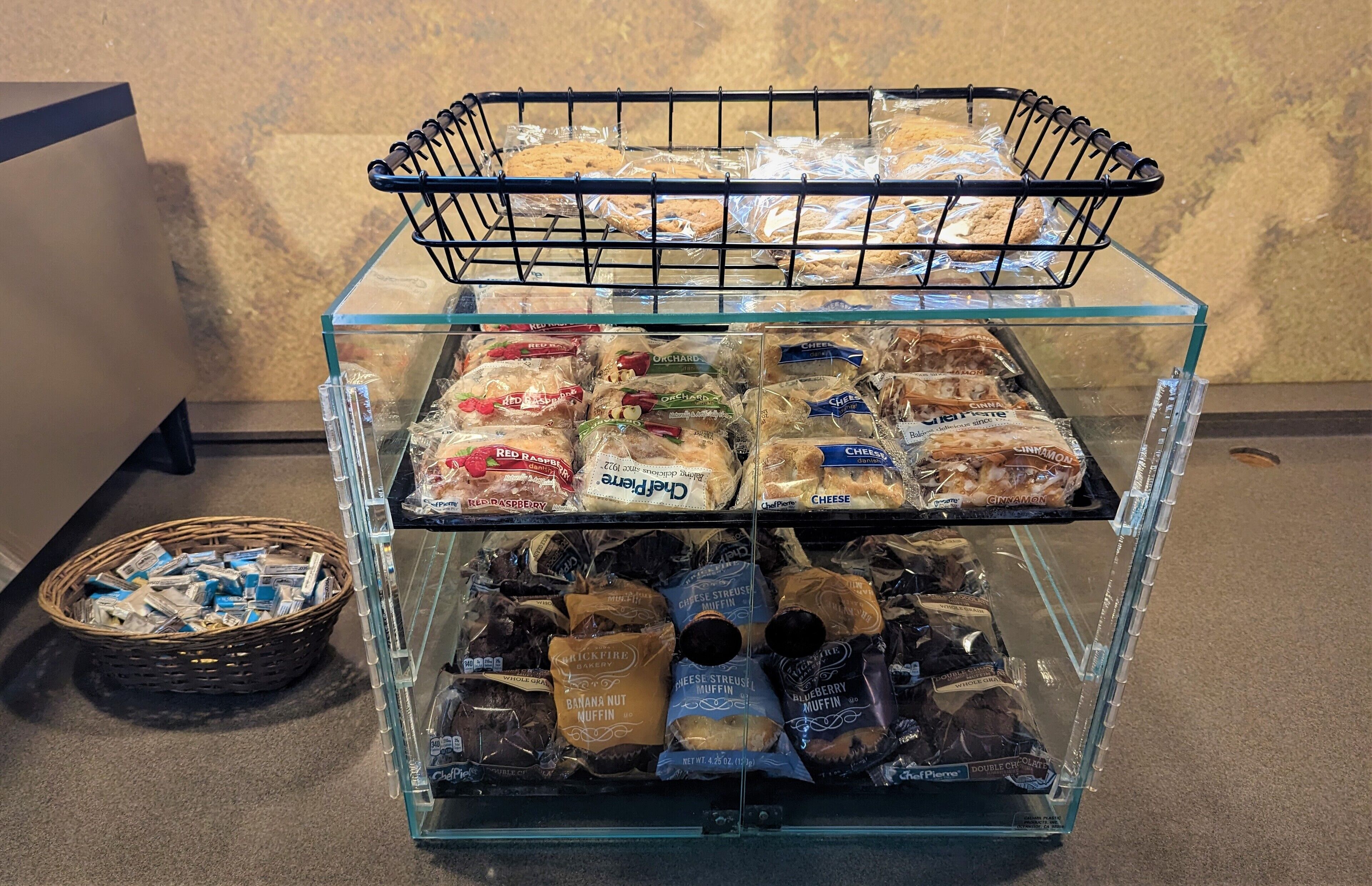 A glass display case with various packaged snacks and cookies.