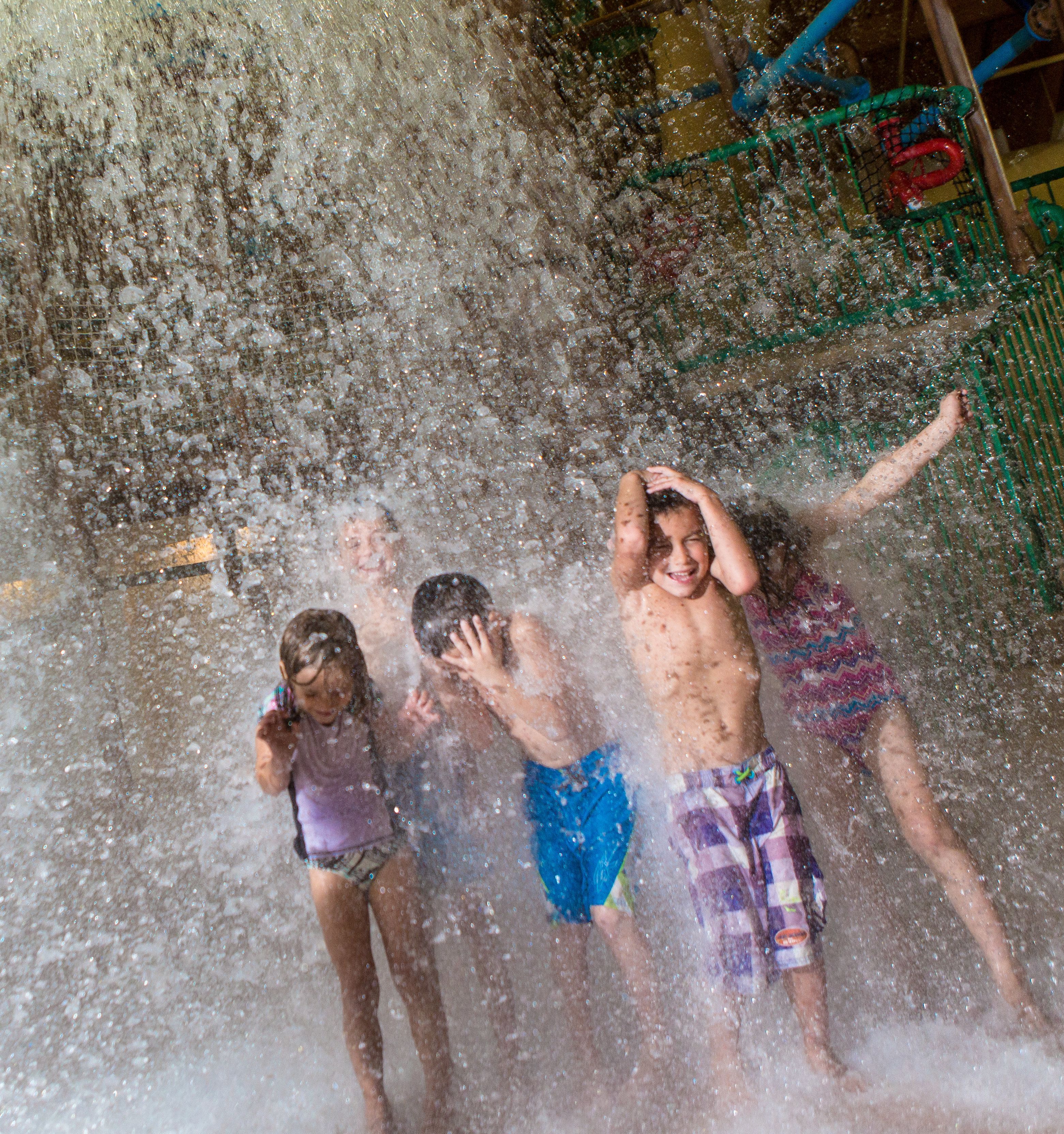 A water play area with multiple children playing.