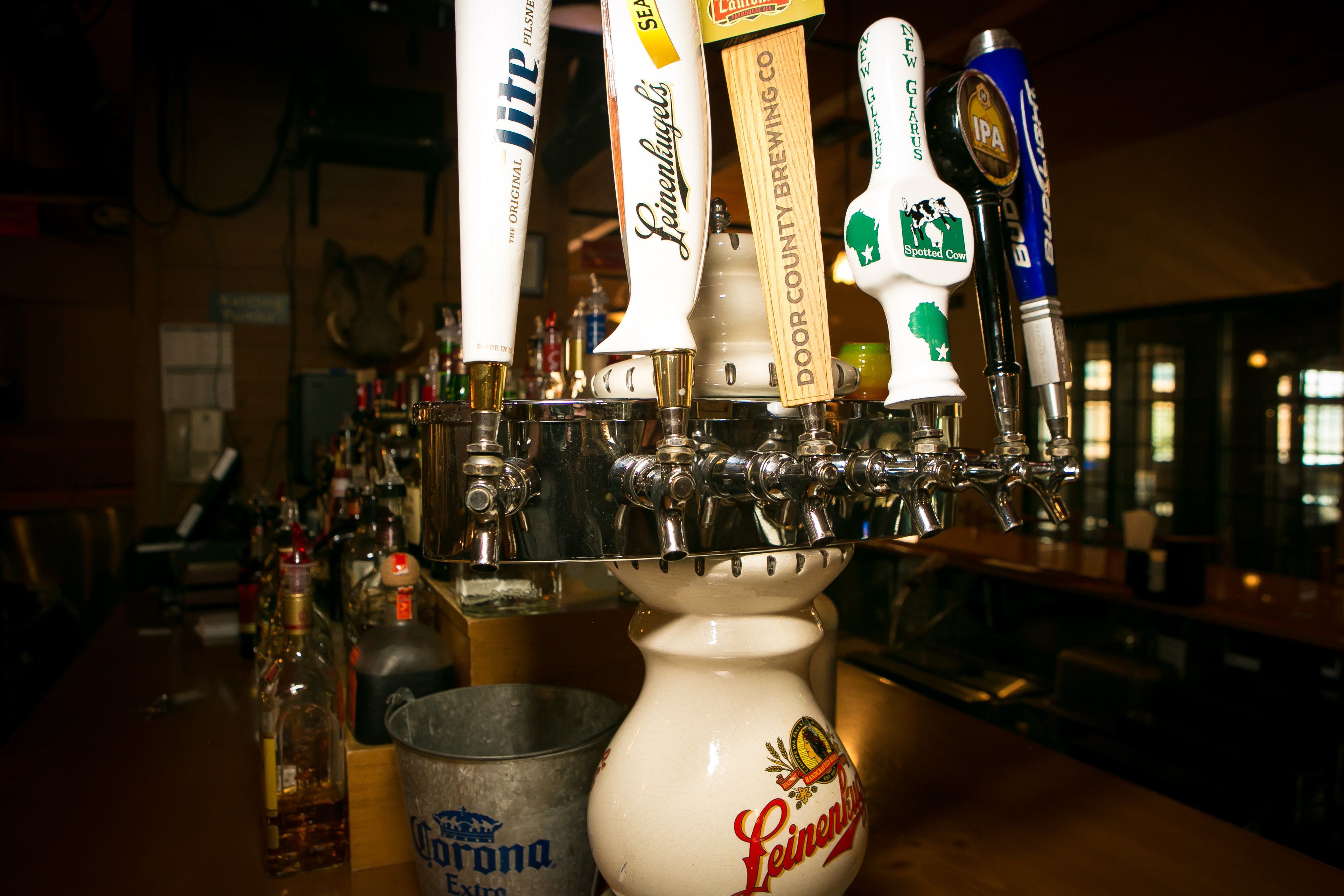 Un bar avec de nombreux robinets à bière et un seau de bières Corona.