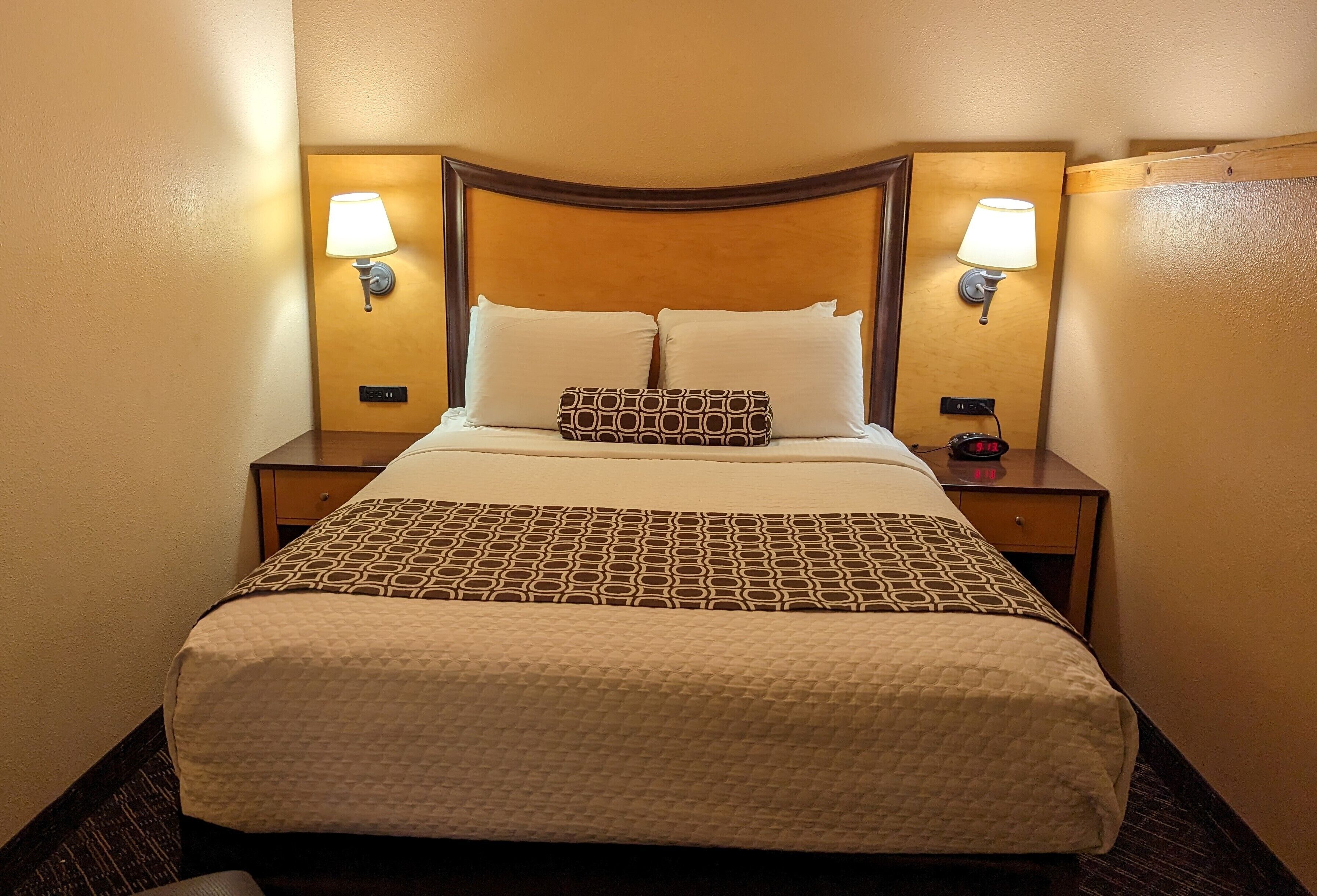 Ein Hotelzimmer mit einem großen Bett, zwei Nachttischen und Wandlampen.