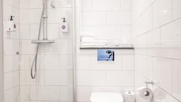 Un baño moderno con ducha, inodoro y perchero para toallas.