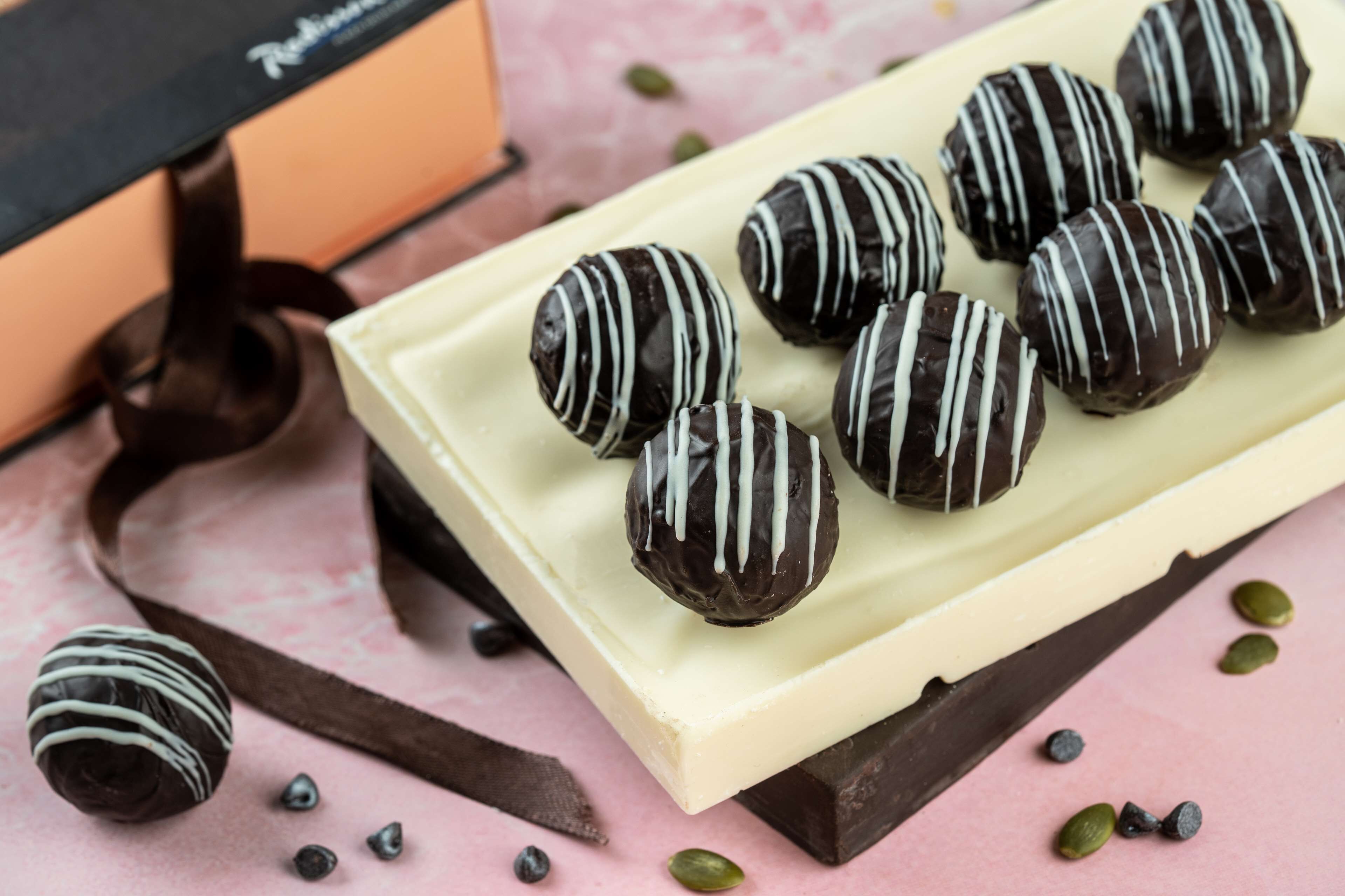 A tray of chocolate-covered truffles on a white plate.