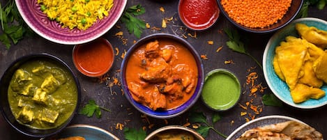 Diversos pratos indianos, incluindo arroz, lentilhas e caril.