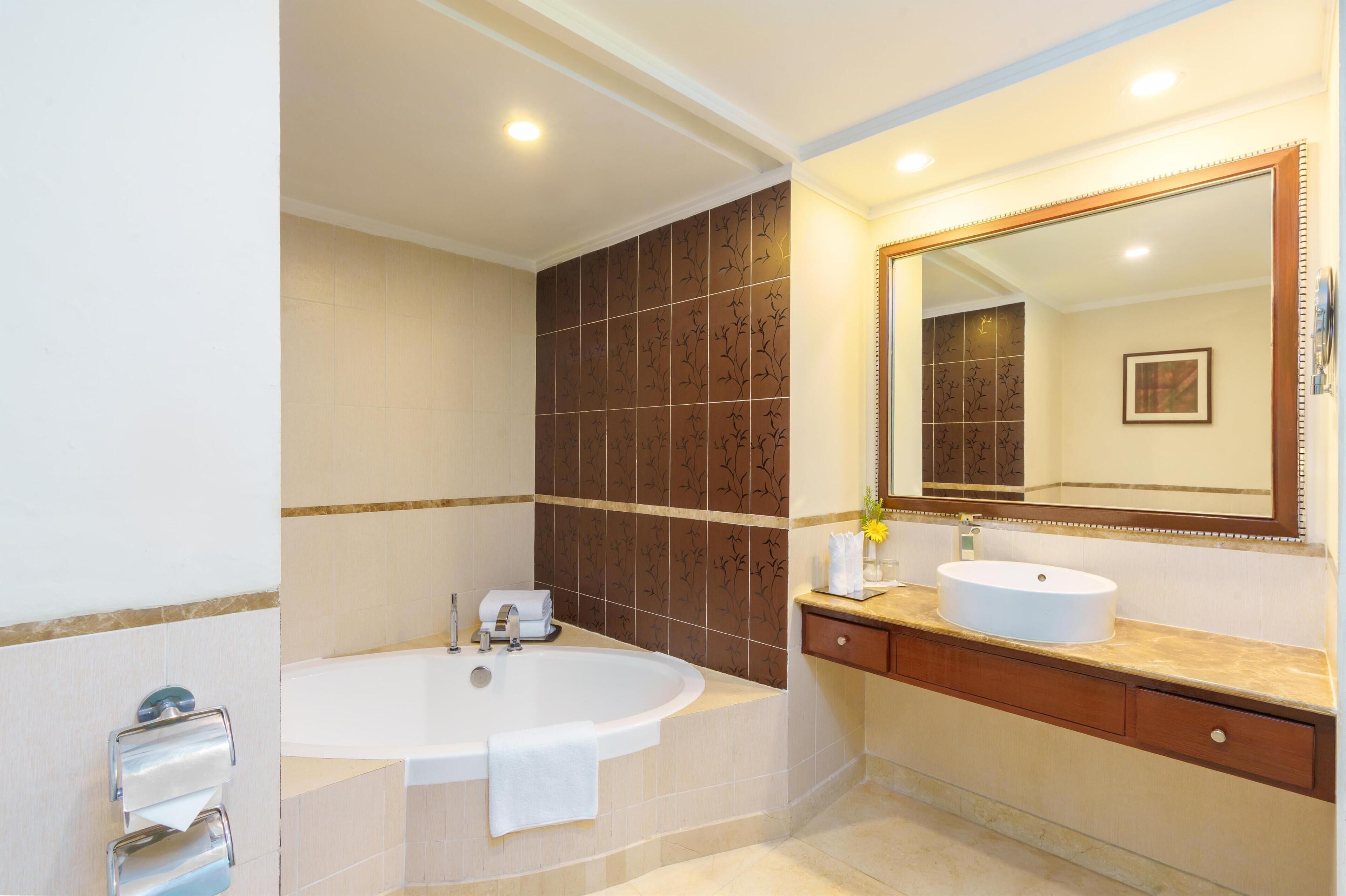 A modern bathroom with a freestanding bathtub, a vanity with a sink, and a large mirror.