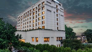 A multi-story Radisson hotel with a modern facade, surrounded by lush greenery. - Radisson Hotel Varanasi (Varanasi)