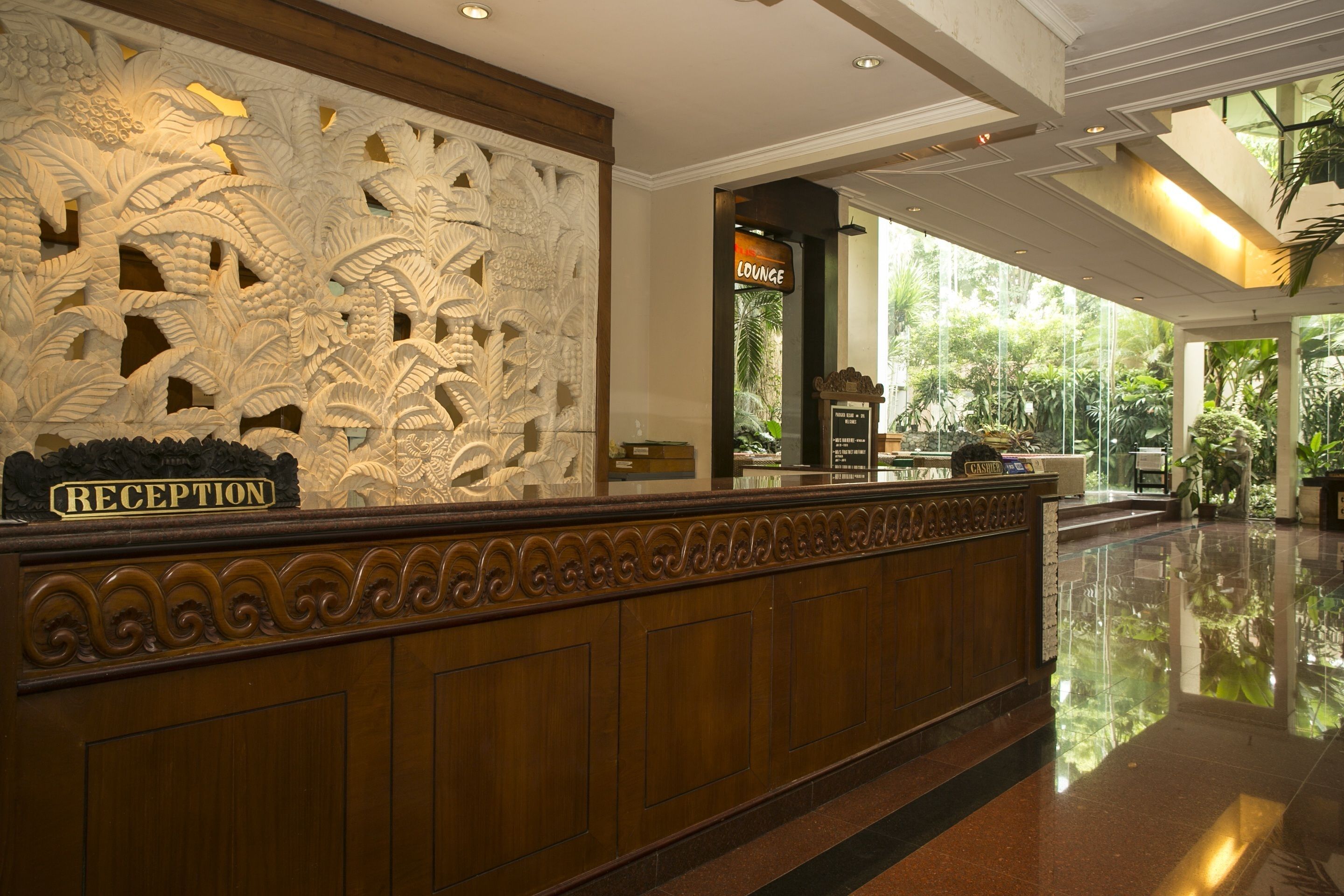 A reception area with a carved wall, a reception desk, and a lounge sign.