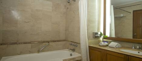 Un baño con bañera, lavabo y espejo.