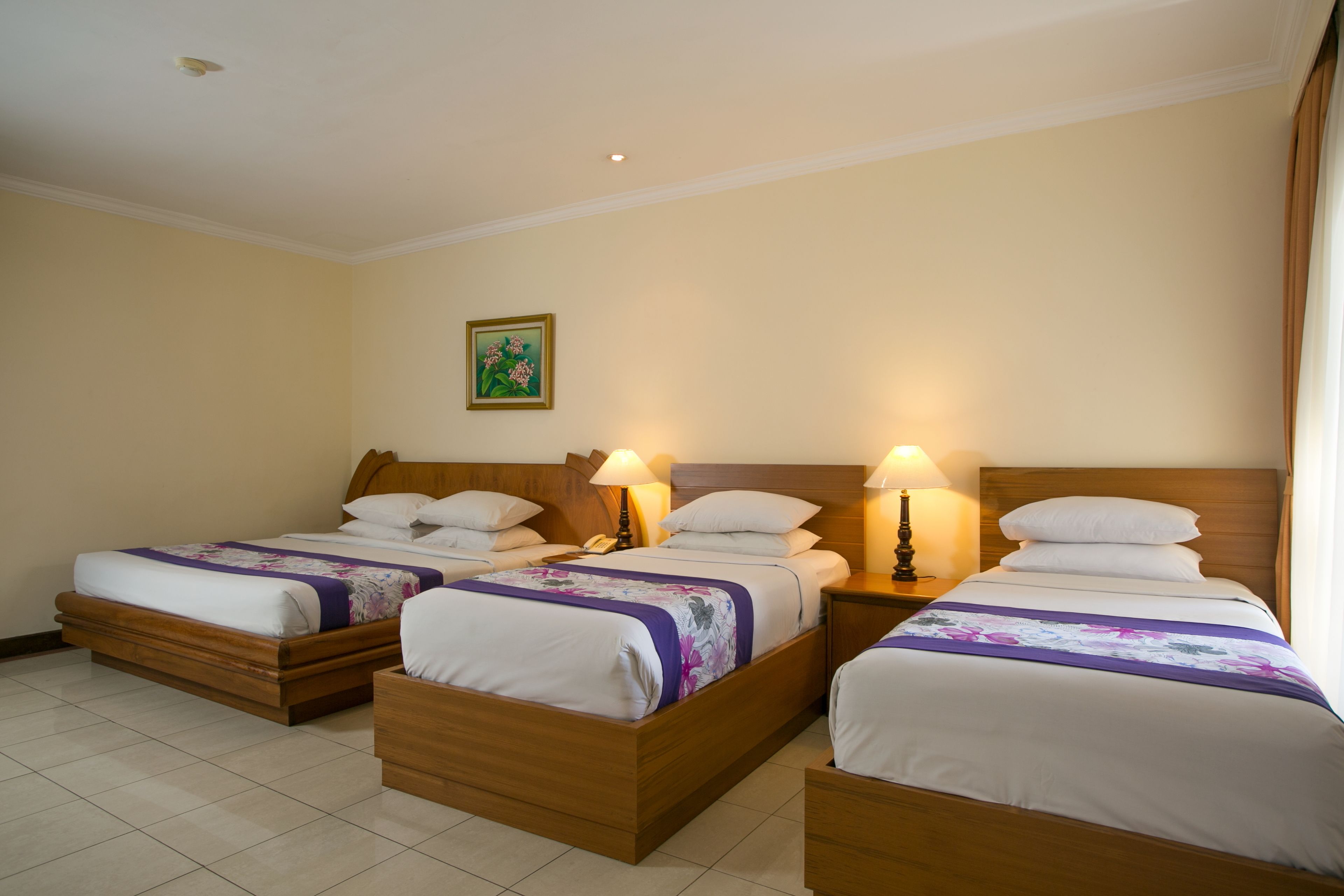 A hotel room with two single beds, wooden headboards, and bedside lamps.