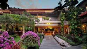 A hotel with a central courtyard, outdoor seating, and lush greenery. - Parigata Resort & Spa (Denpasar)