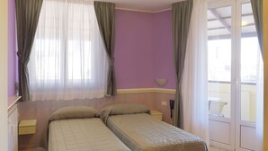 A room with two beds, a window with sheer curtains, a small table, and a view of the outside balcony. - Hotel Arco Romana (Milan)