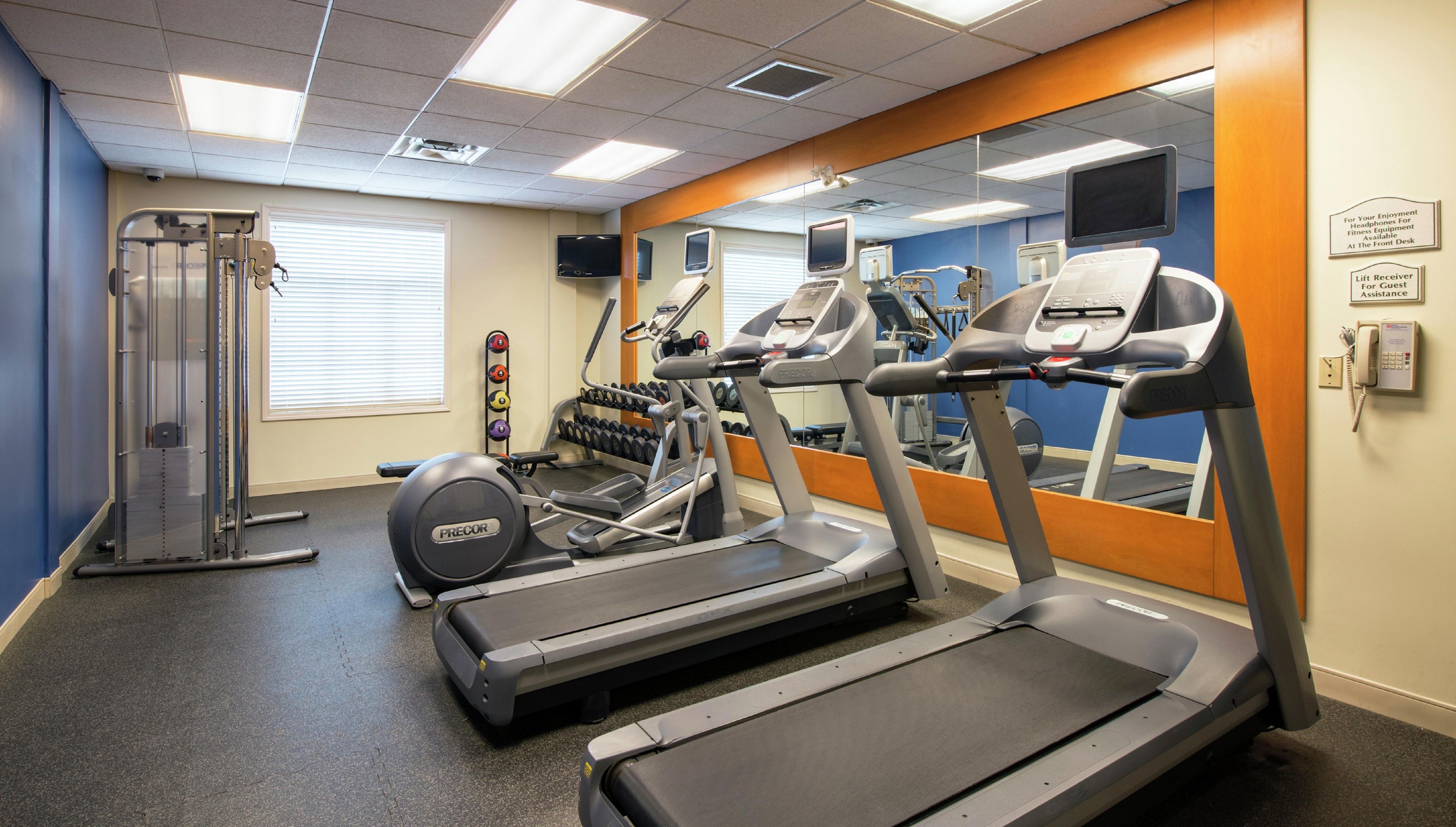 A fitness center with treadmills, a weight machine, and a mirror.