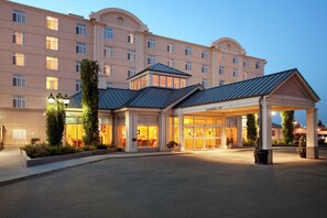 Un hôtel doté d’une entrée abritée, de grandes fenêtres et d’une façade bien éclairée.