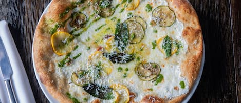 A pizza with various toppings on a white plate.