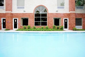 Un bâtiment avec une piscine devant.